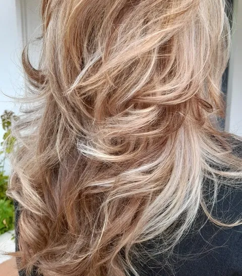 Corte en capas con mechas rubias y acabado ondulado